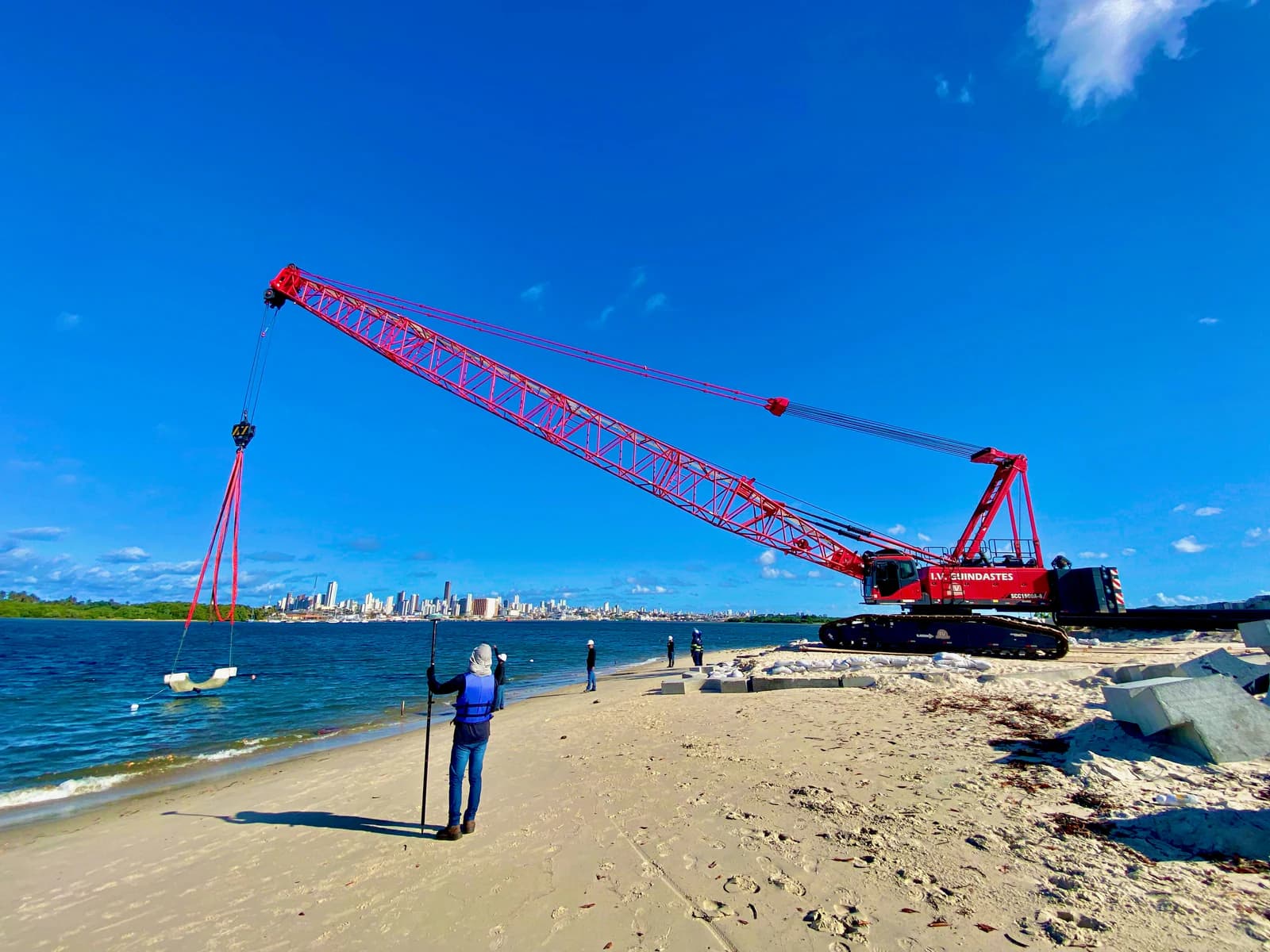 Levantamento batimétrico em obra portuária com guindaste e skyline de Salvador